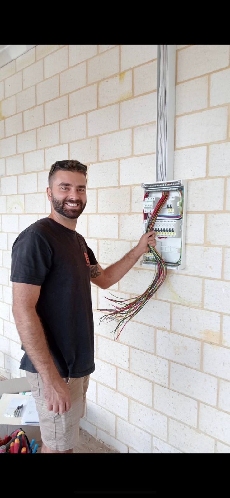 Nuno, licensed electrician and owner of Buetec Electrical, working at a switchboard